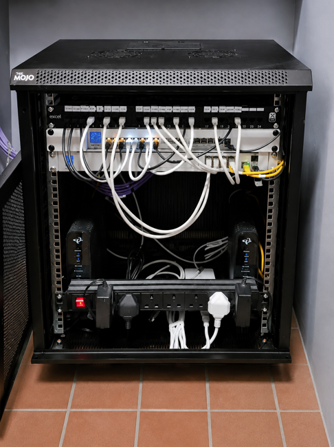 Installed Ubiquiti UniFi business network cabinet with patch panel, switches and fibre links